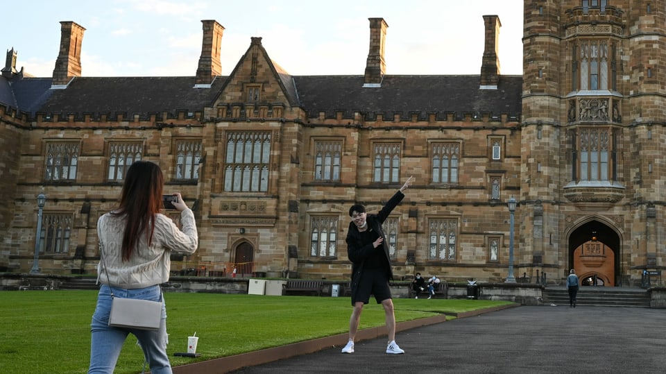 Zwei Studenten fotografieren sich vor der Uni von Sydey.