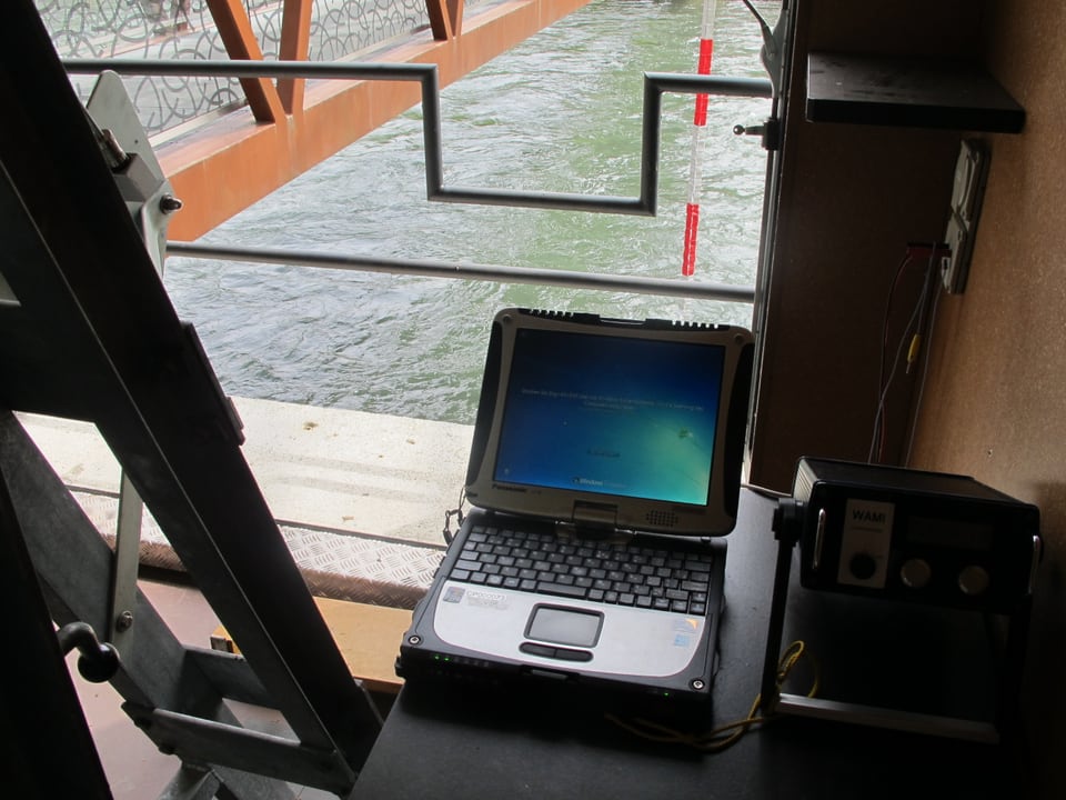 Laptop im Mess-Haus, im Hintergrund der Fluss.