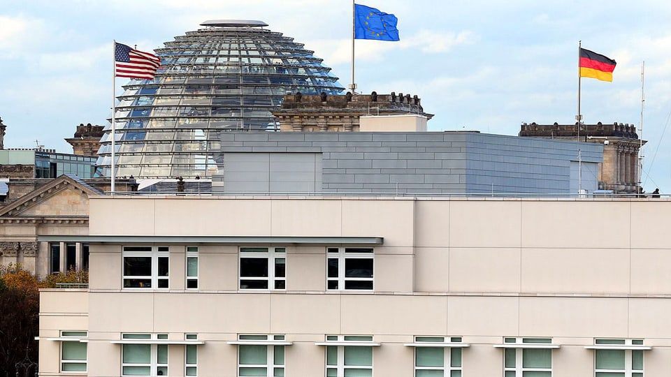 US-Botschaft in Berlin mit Flagge. Im Hintergrund ist der Reichstag erkennbar.