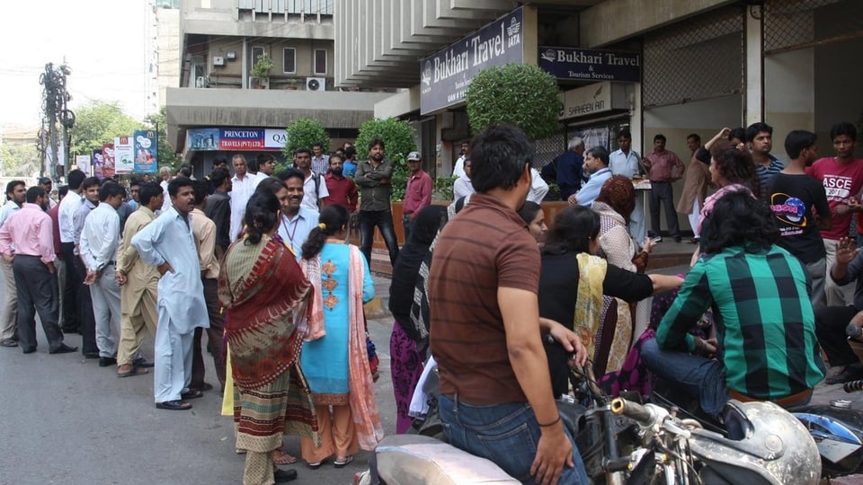 Bewohner der Hauptstadt Karachi stehen auf der Strasse.