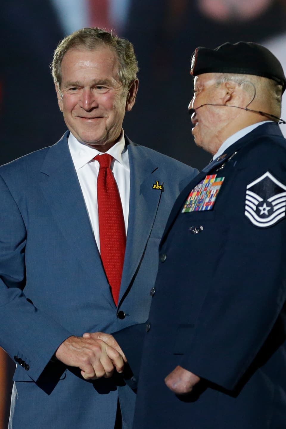 George W. Bush auf der Bühne mit einem Kriegs-Veteranen 