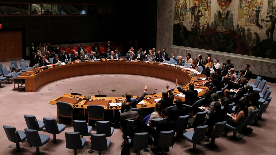Um einen runden Tisch mit Stühlen sitzen die Vertreter des UNO-Sicherheitsrats.