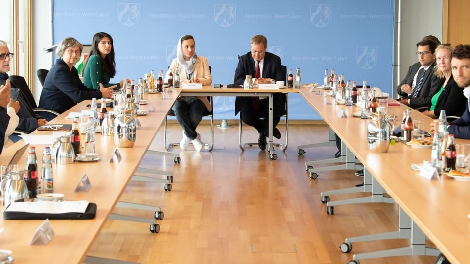 Zarifa Ghafari sitzt mit mehreren Politiker:innen an einem Roundtable.