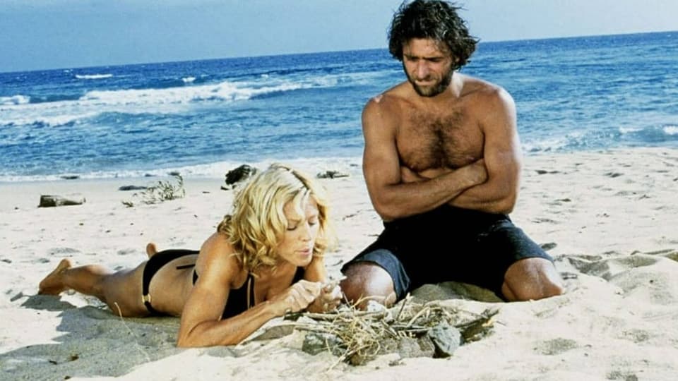 Junges Paar in Badehosen an einem schönen Strand.