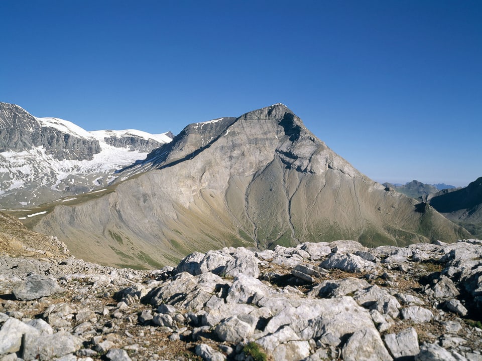Blick von steiniger Anhöhe auf Bergpanorama.