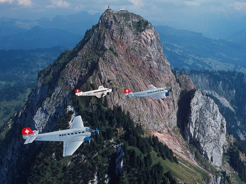 Drei Flugzeuge vor einem Berg