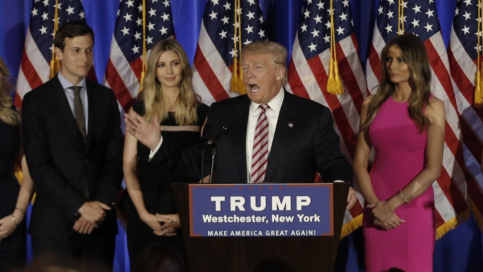 Trump auf einer Bühne, hinter ihm Kushner, Ivanka und Ehefrau Melania.