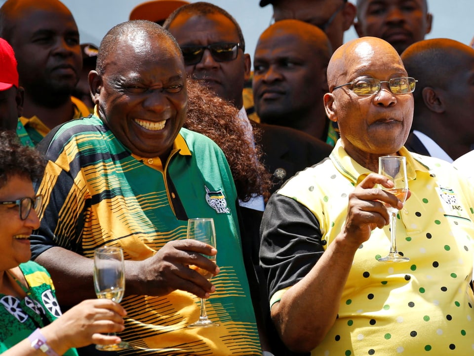 Zuma und Ramaphosa mit einem Champagnerglas.