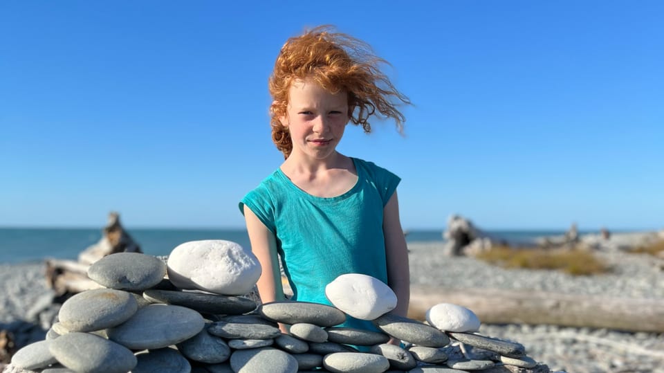 Clara vor einem Steinberg am Strand