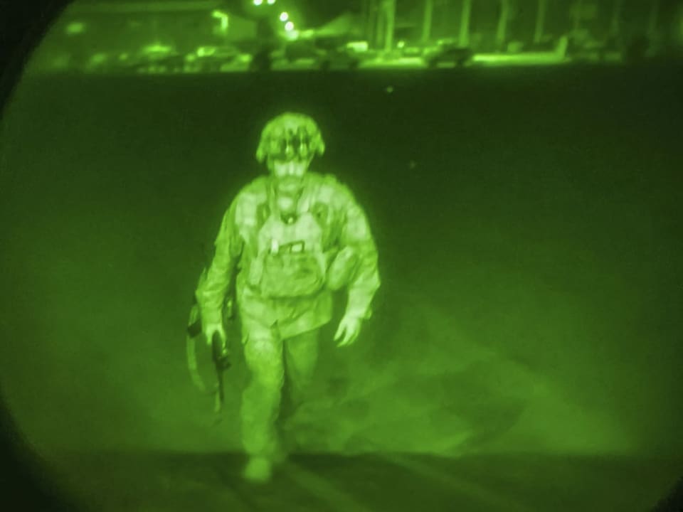 Ein grünliches Bild - gemacht durch ein Nachtsichtgerät - zeigt einen Soldaten, der auf eine Ladefläche eines Flugzeugfrachters zugeht..