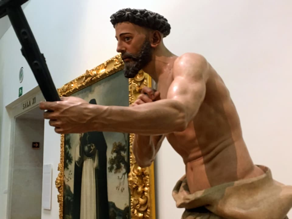Eine realistische Skulptur eines nackten männlichen Körpers mit einem Schwert in der Hand.