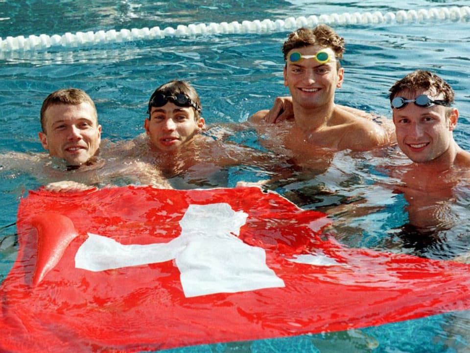 4 Männer im Schwimmbassin mit Schweizer Fahne
