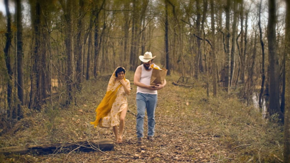 Ein Mann und eine Frau spazieren durch einen herbstlichen Wald