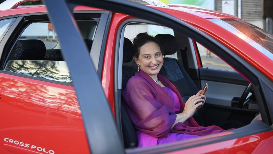 eine Frau mit eleganter Kleidung sitzt in einem Auto
