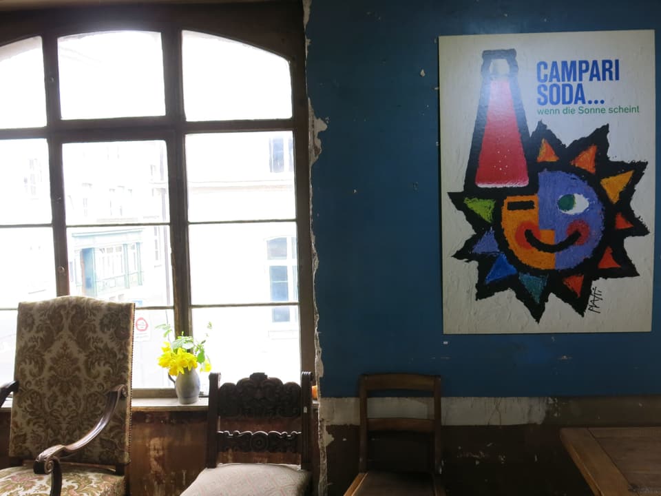 Plakat neben antikuarischen Möbeln.