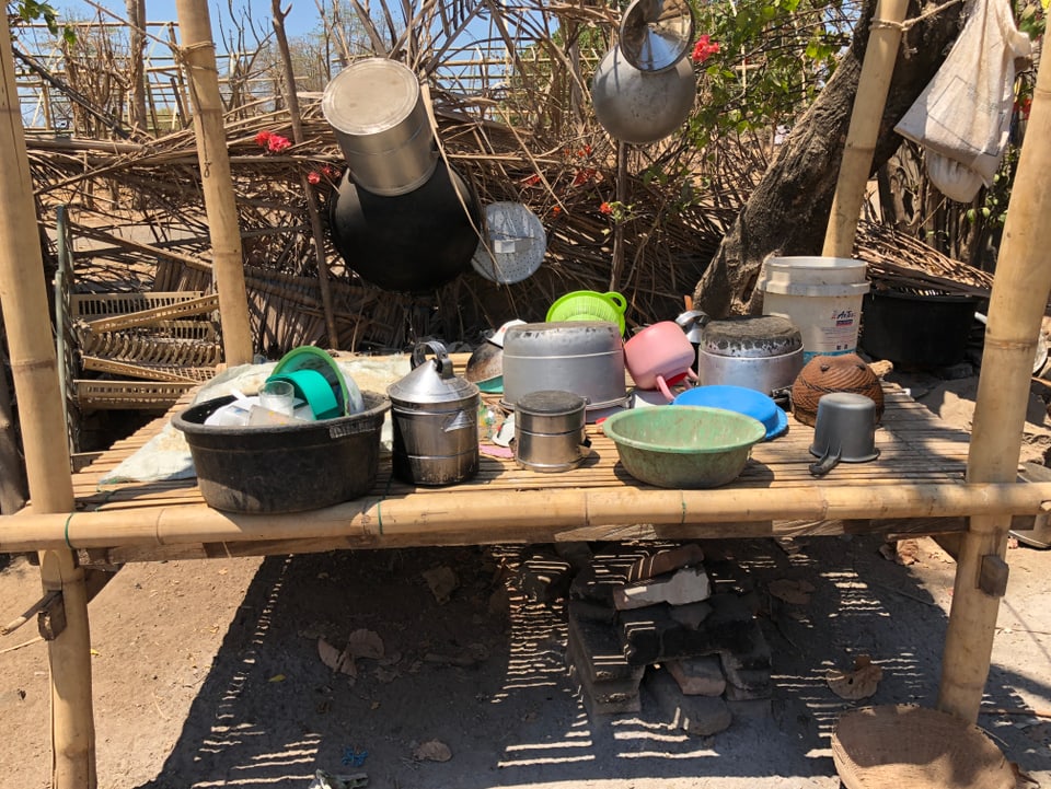 Töpfe und Geschirr auf einer kleinen Ablagefläche aus Bambus.