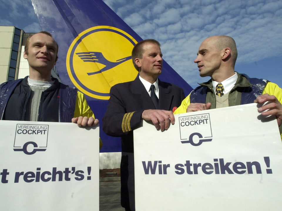 Piloten mit Plakaten, auf denen «Jetzt reichts!» steht. 