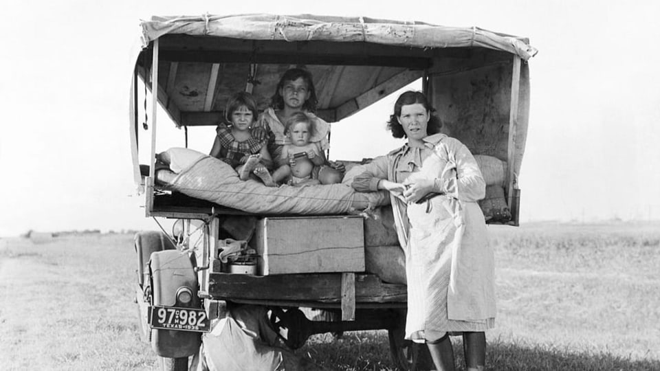 Eine Frau mit ihren drei Kindern in einem Lastwagen auf der Flucht vor einem Sandsturm.