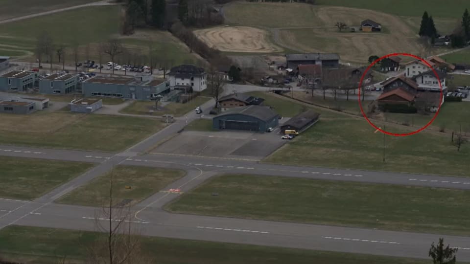 Kleiner Flughafen auf ländlichem Gebiet, rechts eingekreist ein Holzhaus, das Hotel Rössli.