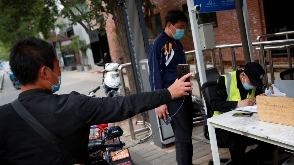Der Fahrer eines Lieferdiensts präsentiert sein seine Gesundheitscode auf seinem Smartphone an einem Kontrollpunkt in Peking.