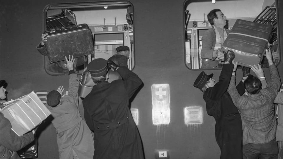 Italienische Gastarbeiter laden ihre Koffer in einen Zug.