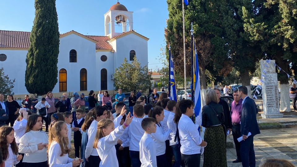 Kinder vor Kirche mit griechischer Fahne.