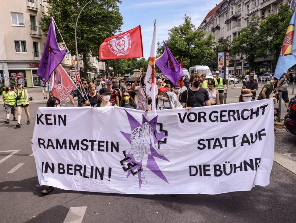 Demonstrierende mit Fahnen und Banner auf dem Weg zum Olympiastadion in Berlin vor dem Rammstein-Konzert.