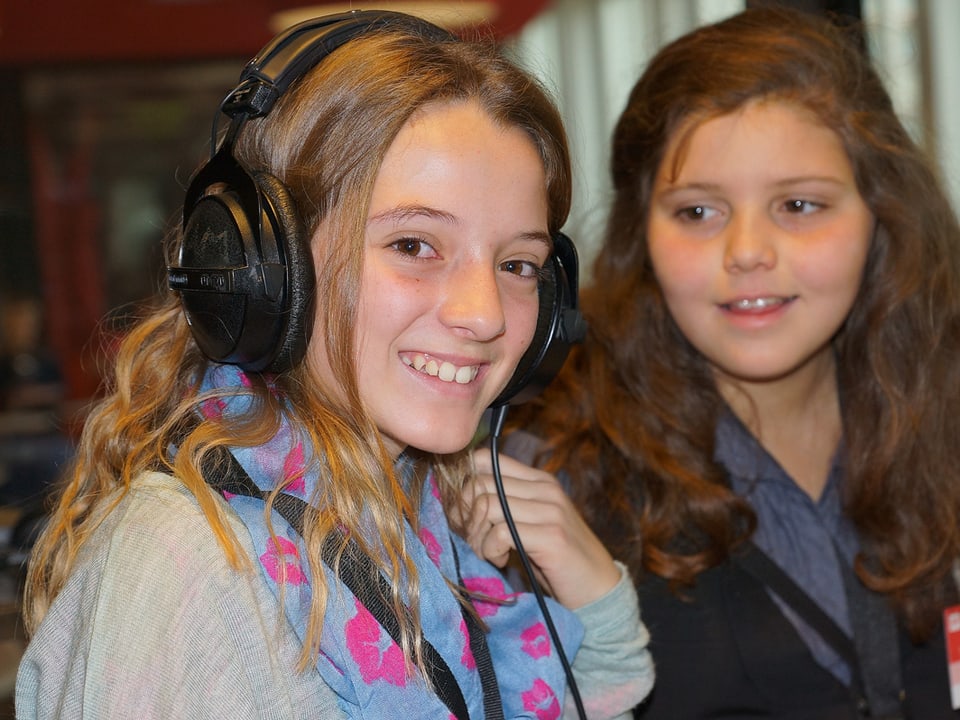 Zwei Mädchen im Studio, eines trägt Kopfhörer.