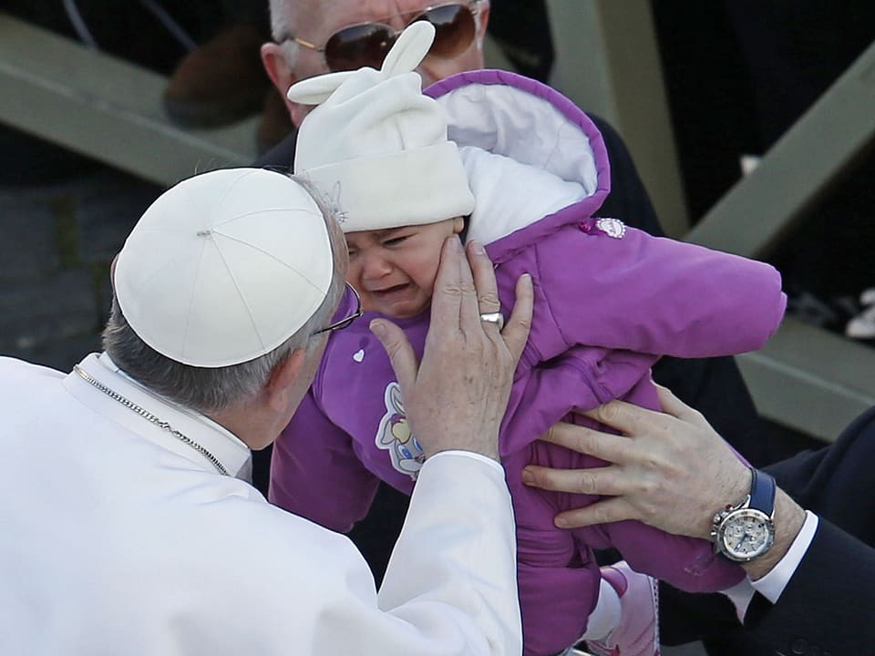 Papst, ein Kind küssend.