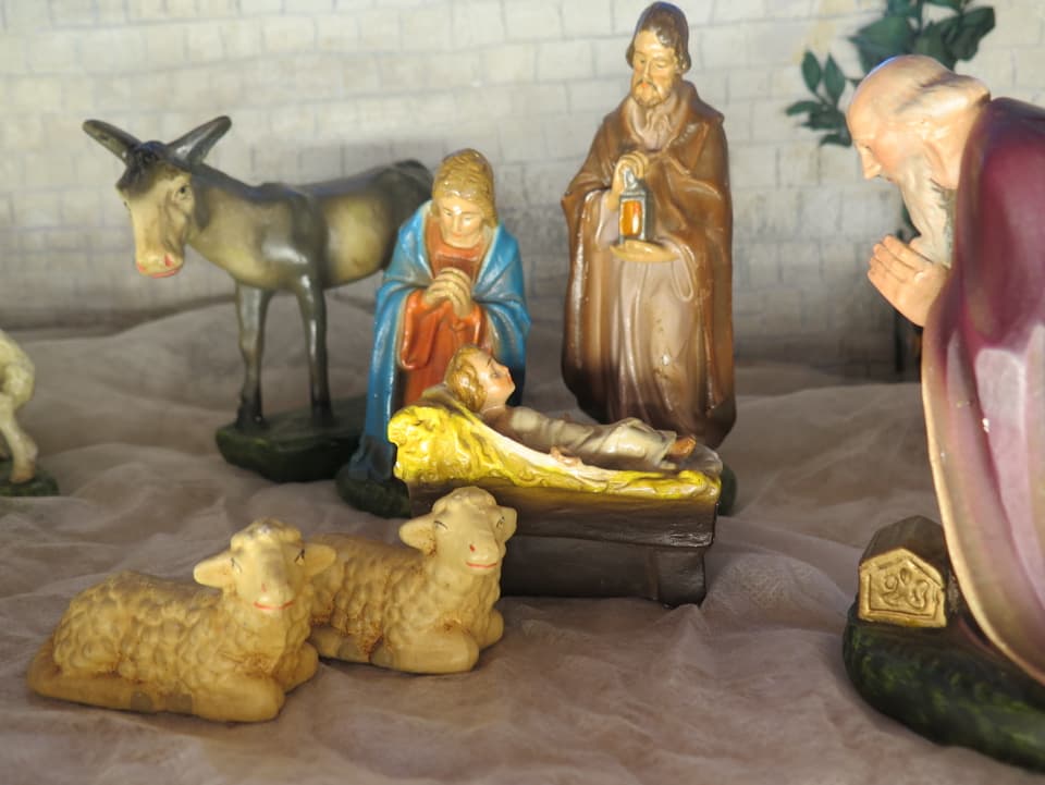 Krippe mit Maria, Joseph und einem Hirten, dazu zwei Schafe und ein Esel
