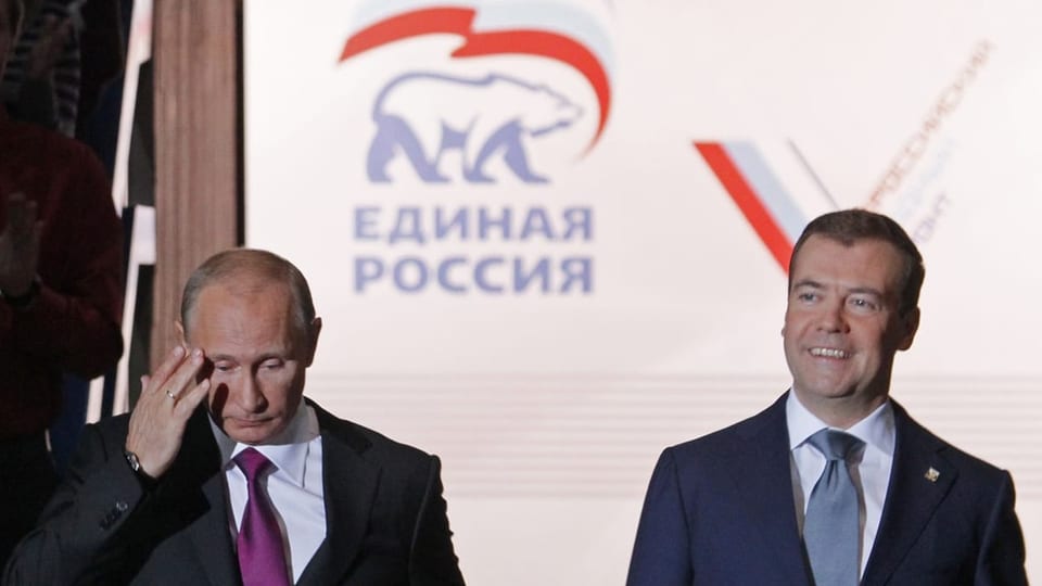Putin und Medwedew stehen vor dem Logo der Partei «Geeintes Russland».