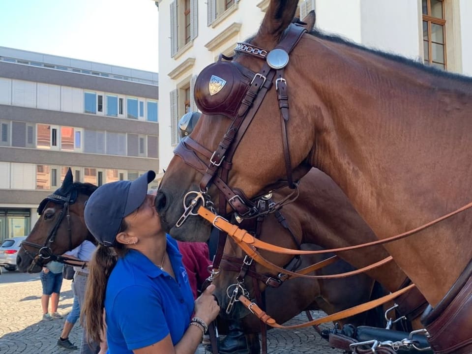 Frau küsst Pferd.