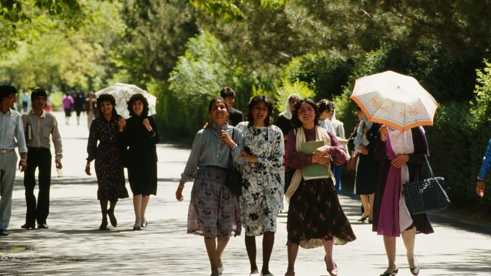 Junge Frauen und Männer flanieren 1988 durch den Park von Kabul. 