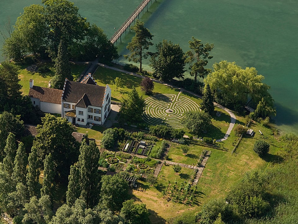 Blick auf ein altes Haus mit wunderschönem Garten am Rhein.