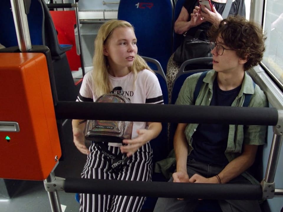 Francesca Ambauen und Finn Krummenacher sitzen in einem Bus