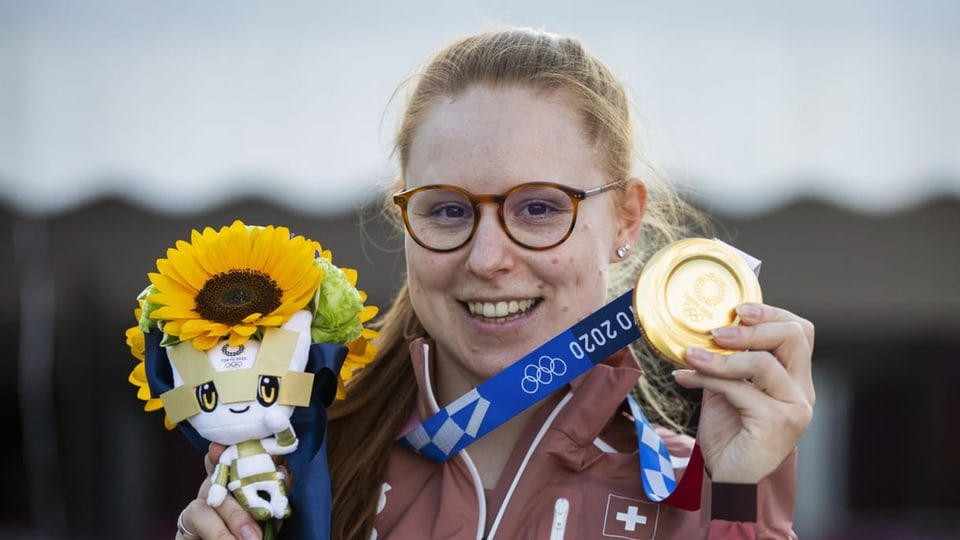 Nina Christen mit Medaille und Maskottchen.