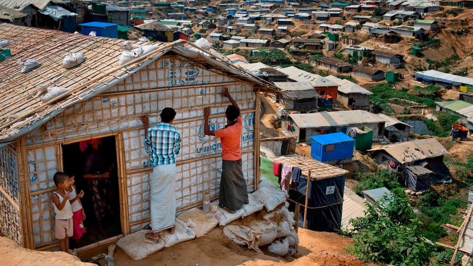 Flüchtlinge bauen eine Hütte zusammen