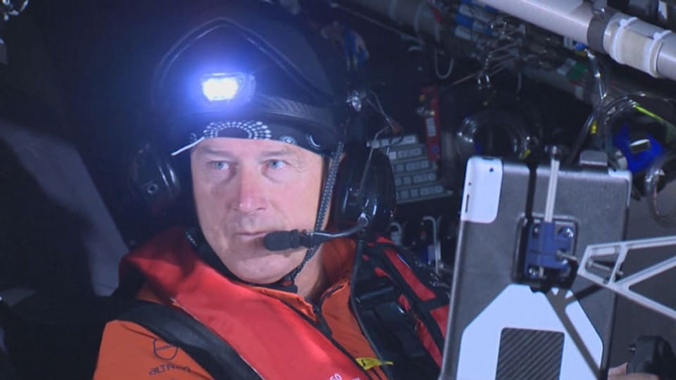 Pilot mit Helm und Funkgerät in Cockpit