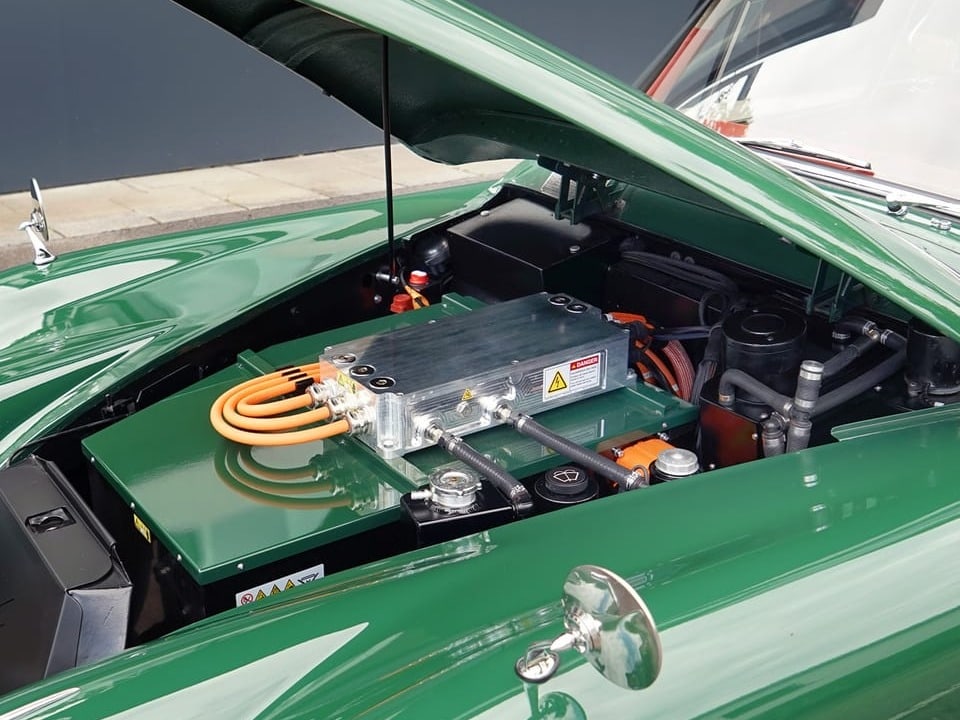 Blick auf grünen Deckel eines Automotoren mit sichtbaren orangfarbenen Schläuchen