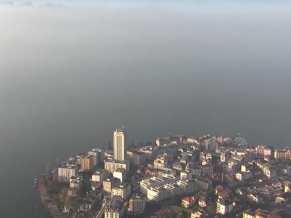 Die Stadt Montreux taucht aus dem Nebel auf.