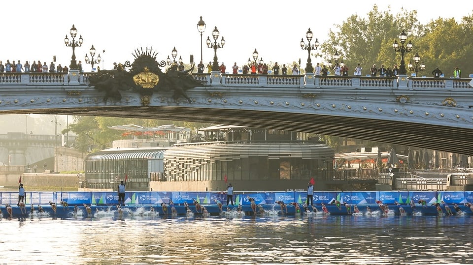 Athletinnen und Athleten schwimmen in der Seine.