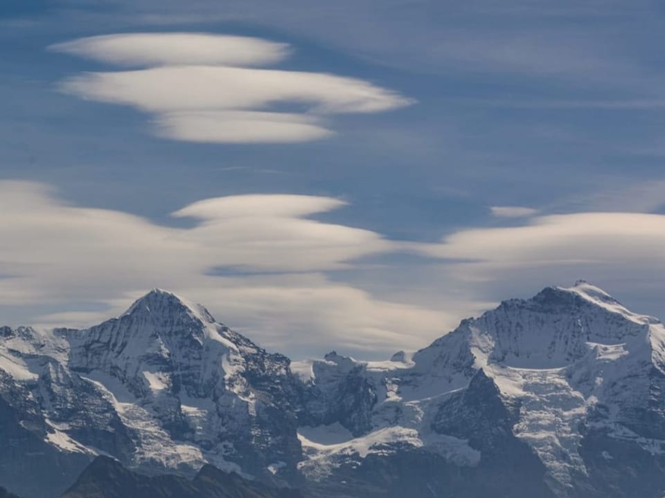Linsenförmige Wolken über Schneebergen