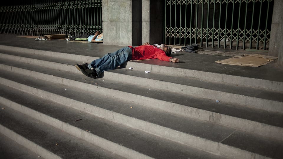 Ein obdachloser Mann liegt auf einer Treppe in Argentinien.