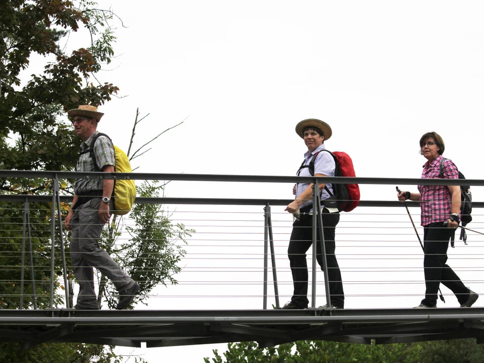 Drei Wanderer auf der Brücke.