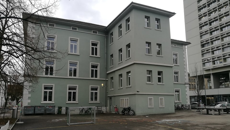 Grau-grünes Steingebäude.