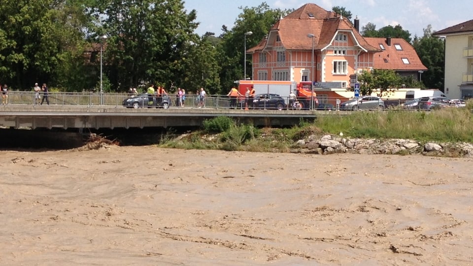Nach der Flutwelle im Oberlauf  (Schangnau) erreicht das Emme Hochwasser Biberist. Das schlamige Wasser strömt gerade noch unter einer Brücke hindurch.