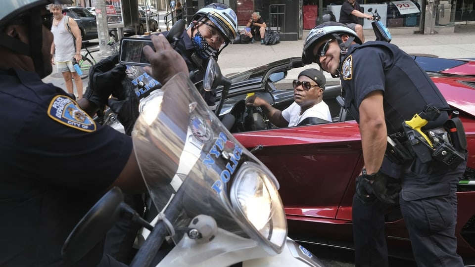 Komiker Tracy Morgan posiert für ein Foto mit Polizisten, die den Protest in New York beobachteten.