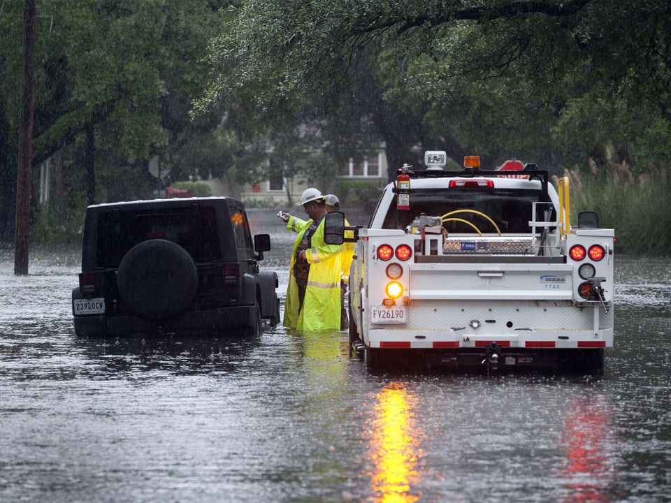 Auf der Orange Street in Georgetown navigiert die Autohilfe einen verirrten Personenwagen durch das überflutete Strassennetz. (reuters)