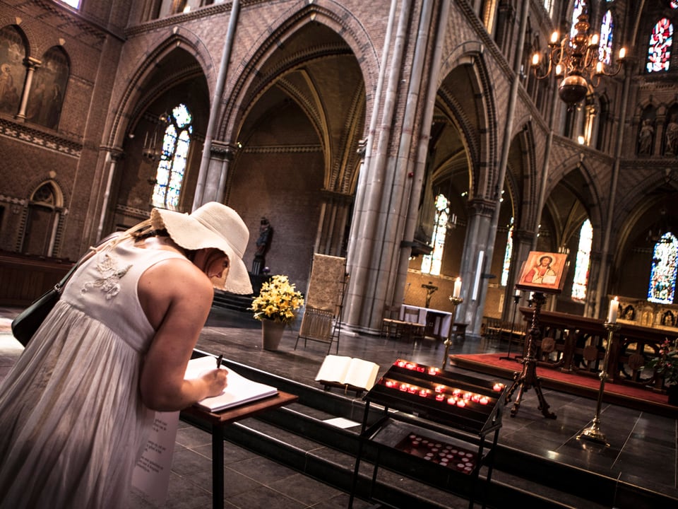 Eine Frau unterzeichnet ein Beileidsregister für die verunglückten Passagiere der MH17 in einer Kirche in Eindhoven.