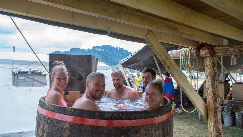 Mitglieder der Pfadi Rothenburg kühlen sich im Kantonslager «LUpiter 18» ein einem grossen Bottich voller Wasser ab.